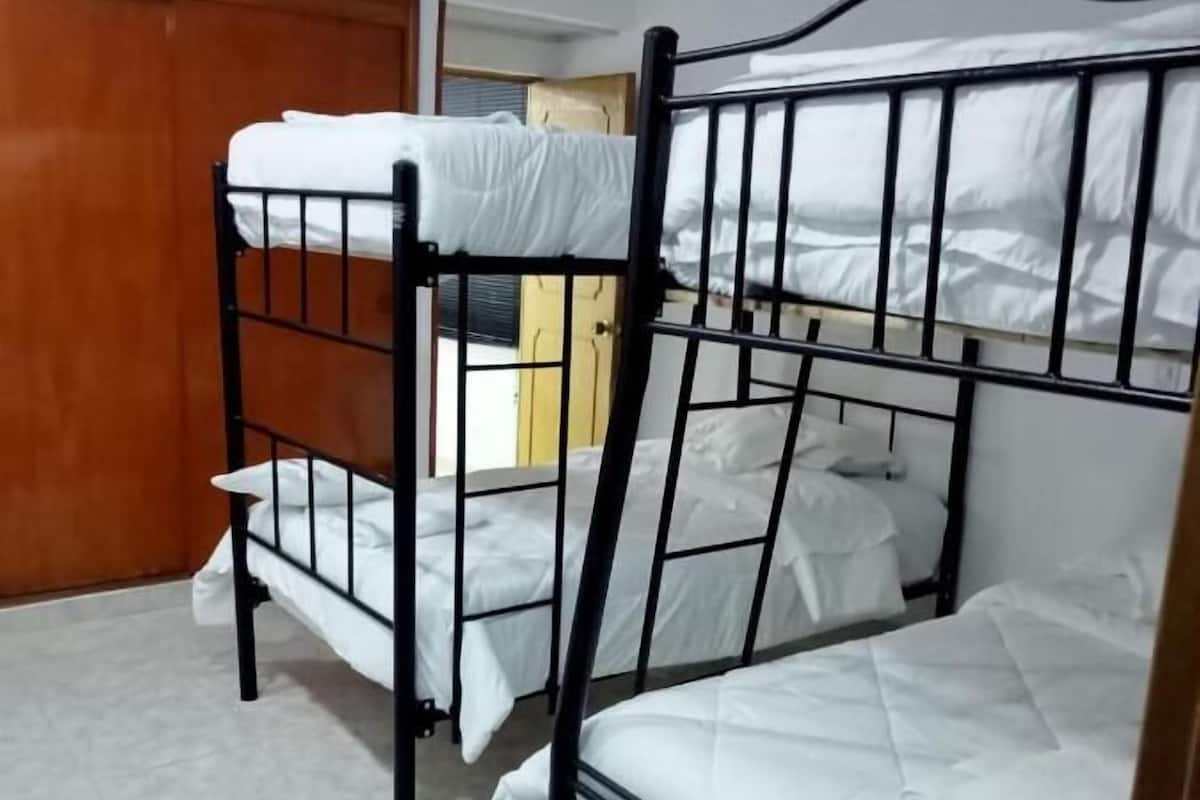 A room with bunk beds and a wooden door.
