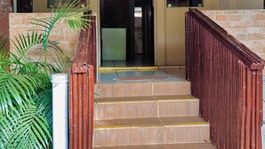 A staircase leading to an entrance with a metal railing, a door, and a ceiling fan. - Pousada Golfinho (Fernando de Noronha)