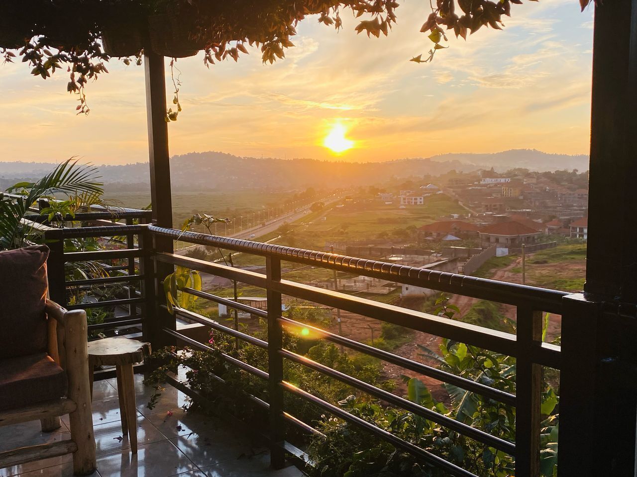 Un balcon offrant une vue sur le coucher de soleil au-dessus d’une ville.