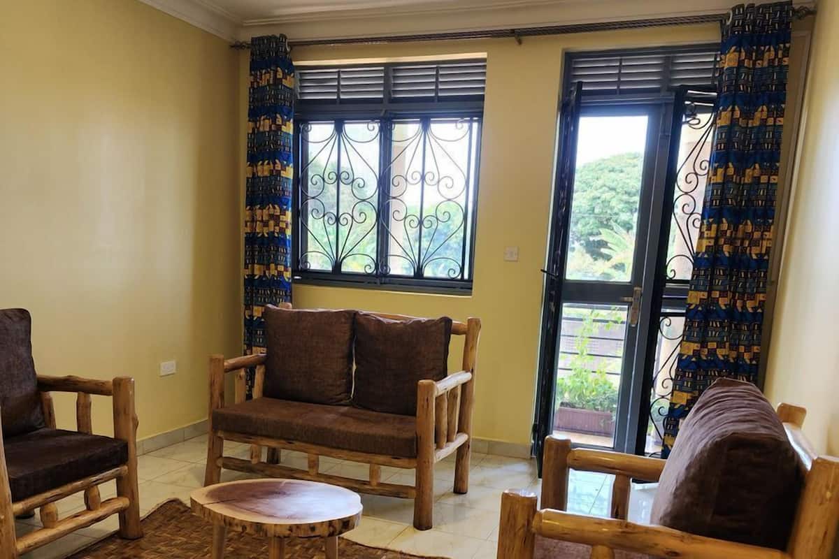 A living room with a sofa, two armchairs, a coffee table, and a patterned rug.