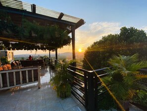 A rooftop terrace with seating and a view of the sunset. - Kitiko Residence Hotel (Kampala)