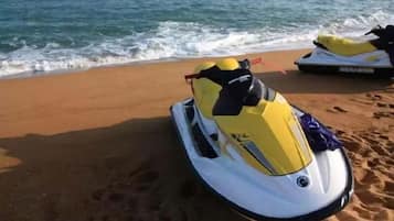 A jet ski on a sandy beach with the ocean in the background.