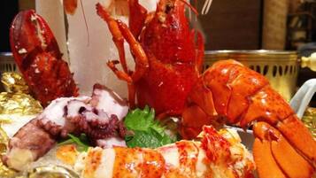 A lobster dish with a side of seafood and a decorative centerpiece.