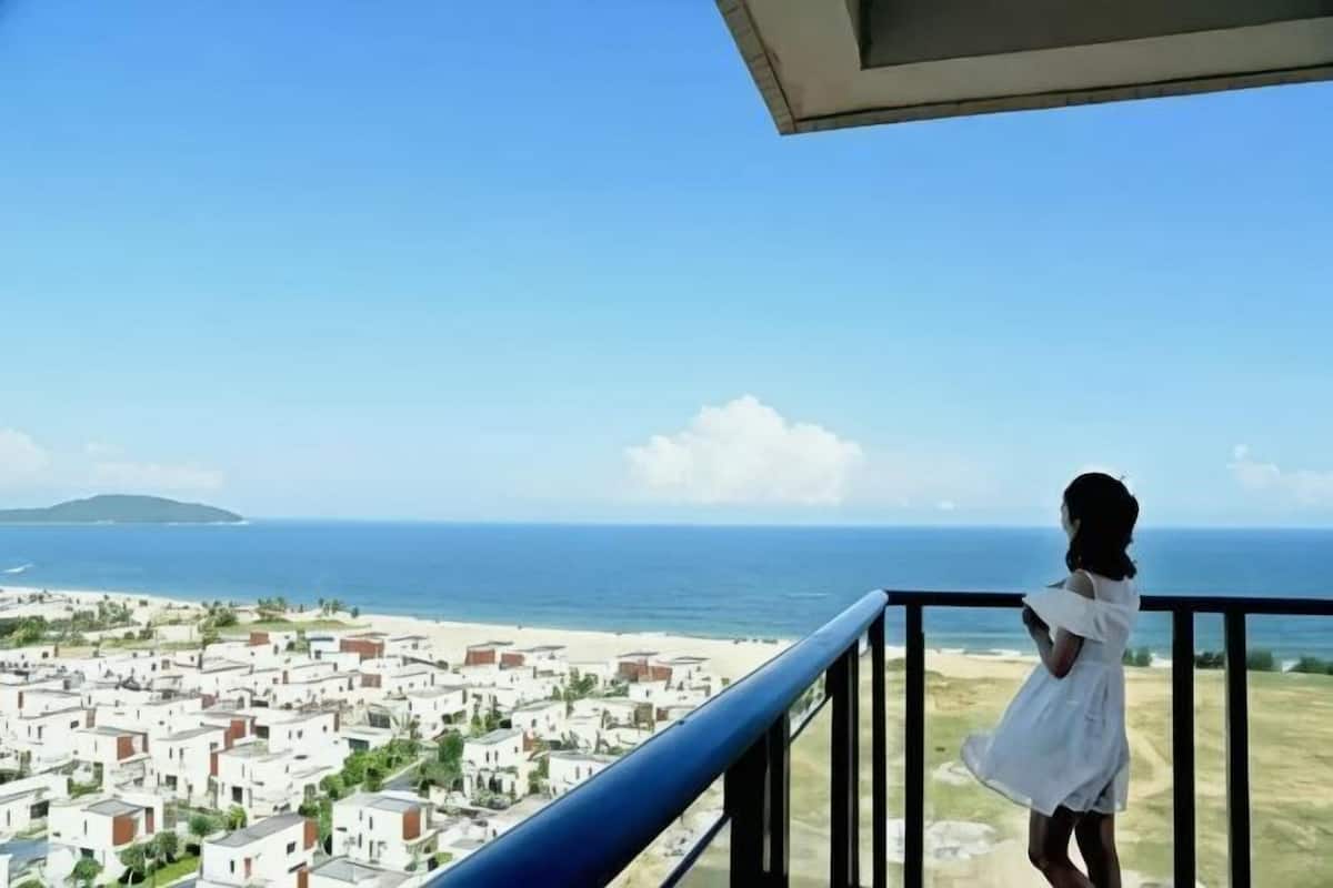 A balcony with a view of the sea and buildings.