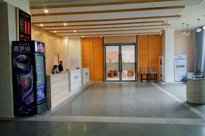 A hotel reception area with a digital display, reception desk, and seating area. - Yangxi Shapa Moon Bay Xingyue Apartment (Yangxi)