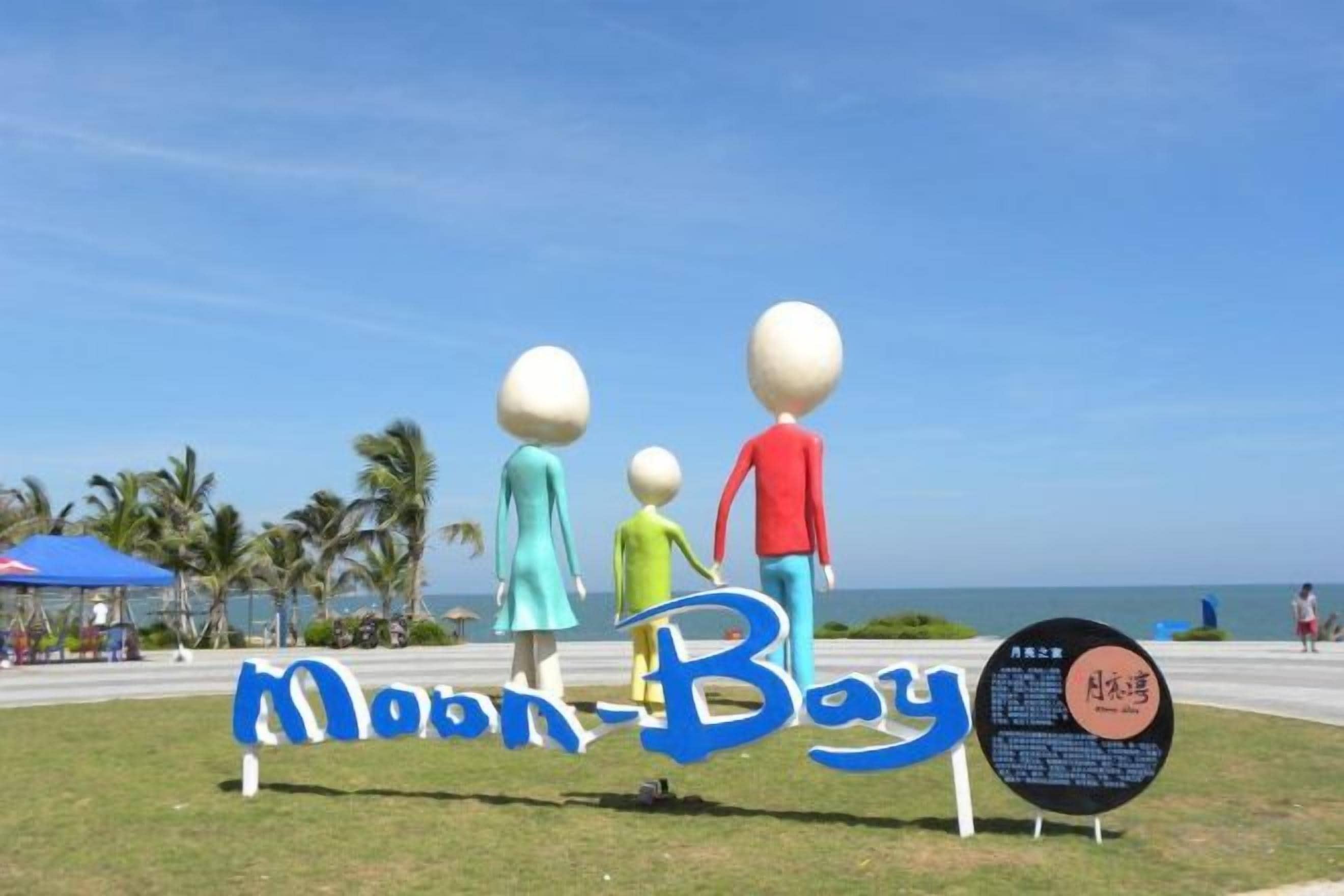 A beach sign with the text 'Moon Bay' and a family of figures.