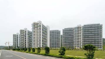 A row of high-rise residential buildings with a clear road in front.