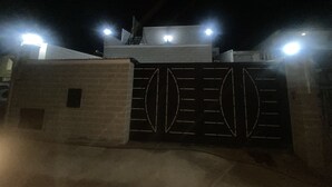 A gated entrance at night with illuminated lights. - Maison Individuelle - Ait Chafaa Azeffoun (Aït Chafâa)