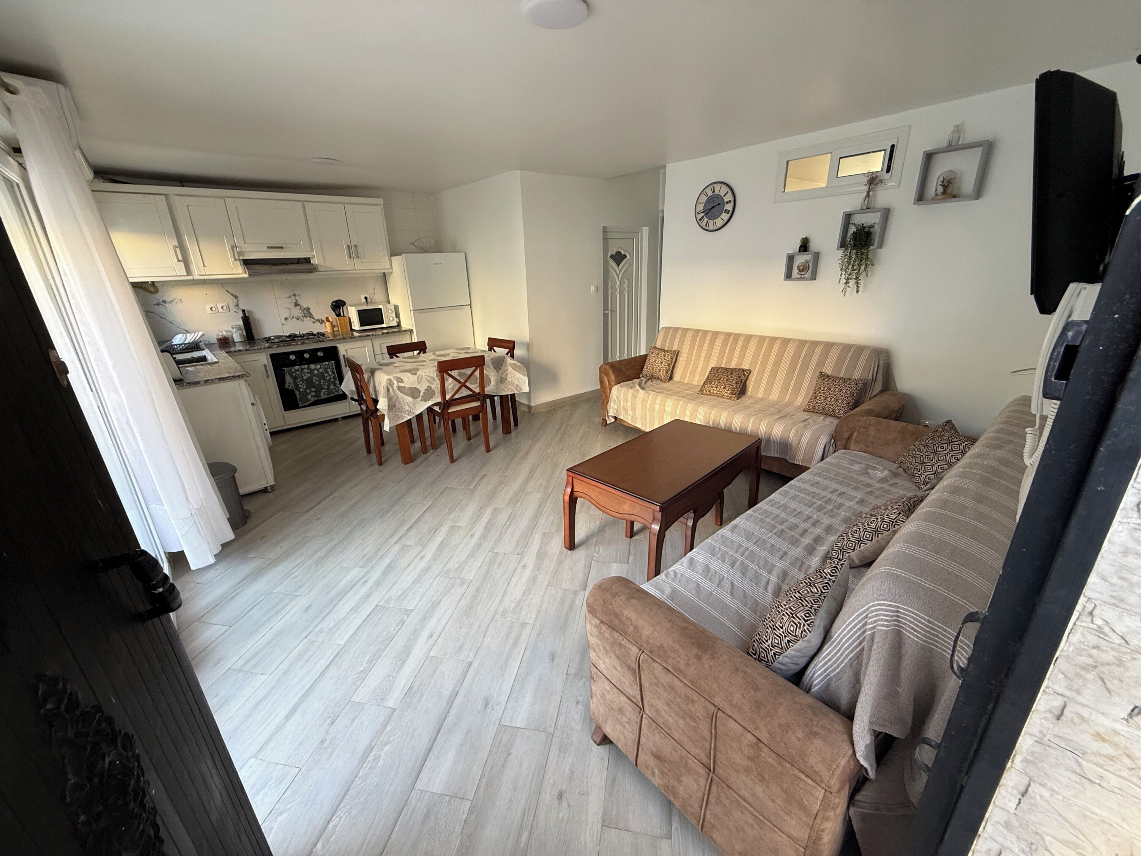 Ett vardagsrum med en soffa, ett soffbord och en matplats med ett bord och stolar.
