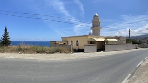 A mosque with a dome and minaret, located beside a road with a view of the sea. - Maison Individuelle - Ait Chafaa Azeffoun (Aït Chafâa)