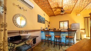 A kitchen with a bar area, a sink, and a refrigerator. - Casa Happy Sol - Delfin (San Francisco)