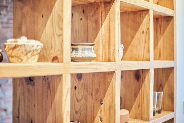 A wooden shelf unit with a bowl and a decorative plate. - Charming European-style Studio in the Historic Orenge Building, Downtown Durham. (Durham)