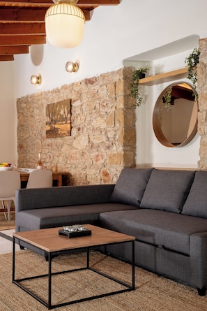 Suite Deluxe | Área de sala de estar | Televisión de 32 pulgadas con canales por cable