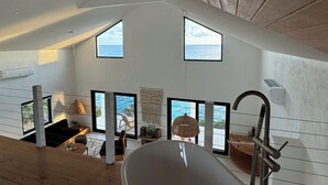 Ruime kamer met grote ramen en uitzicht op de oceaan, een moderne keukenhoek en een gezellig zithoekje met een prachtig panorama.