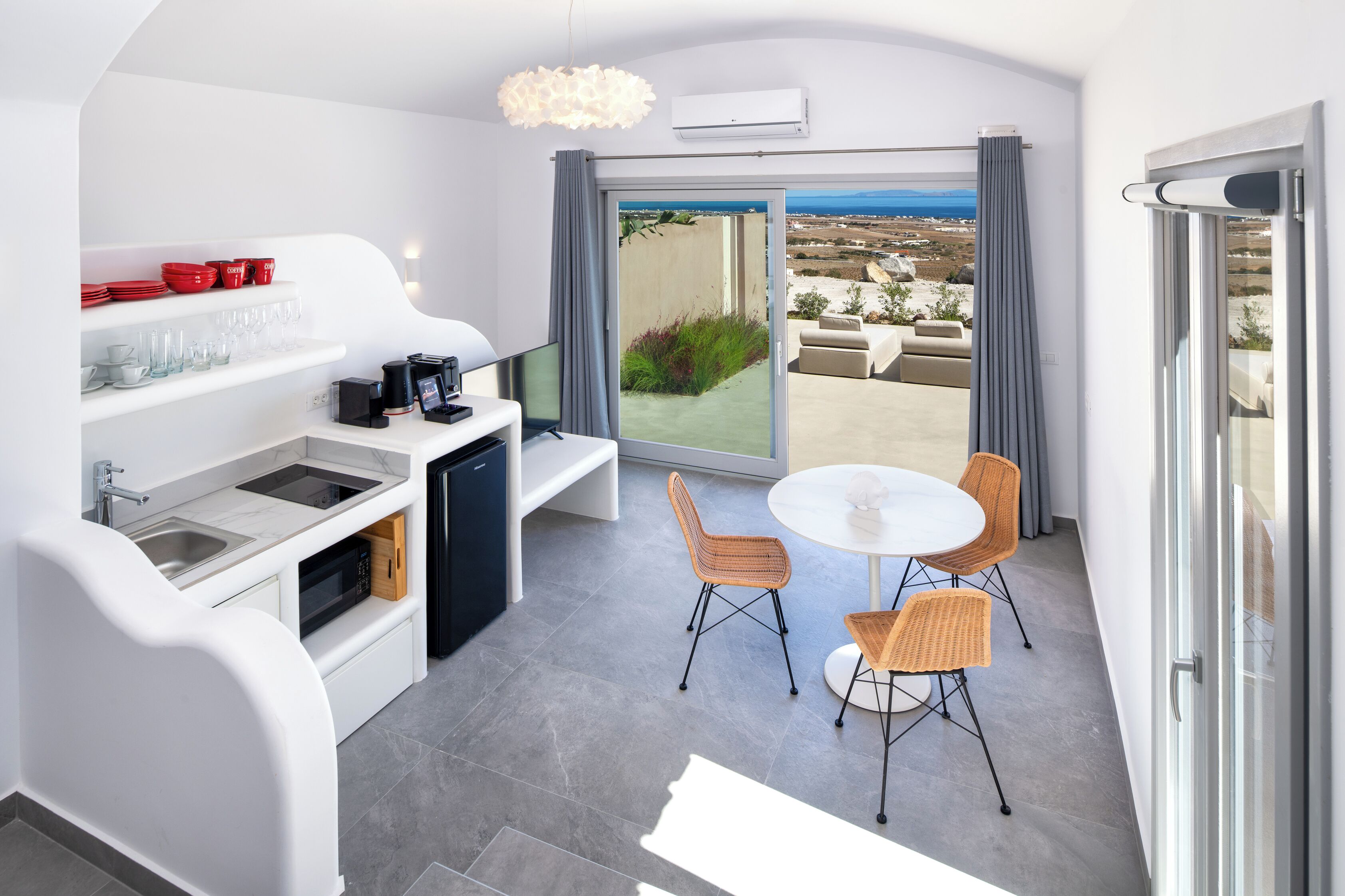 Une cuisine moderne avec un coin repas, un téléviseur et une vue sur la mer.