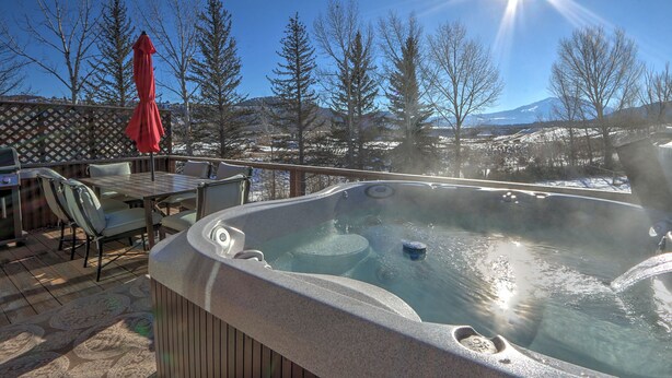 A hot tub on a deck with a view of a snowy landscape and trees. - Hot Tub with Amazing Views, Game Room, Family Friendly, Central Location (Glenwood Springs)