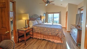 A bedroom with a bed, a desk, a chair, a television, and a ceiling fan. - Hot Tub with Amazing Views, Game Room, Family Friendly, Central Location (Glenwood Springs)