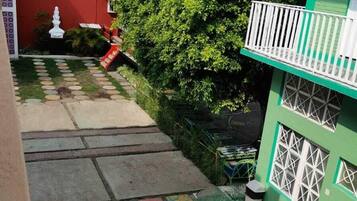 Una escalera con baldosas coloridas que lleva a un edificio verde con barandillas blancas.