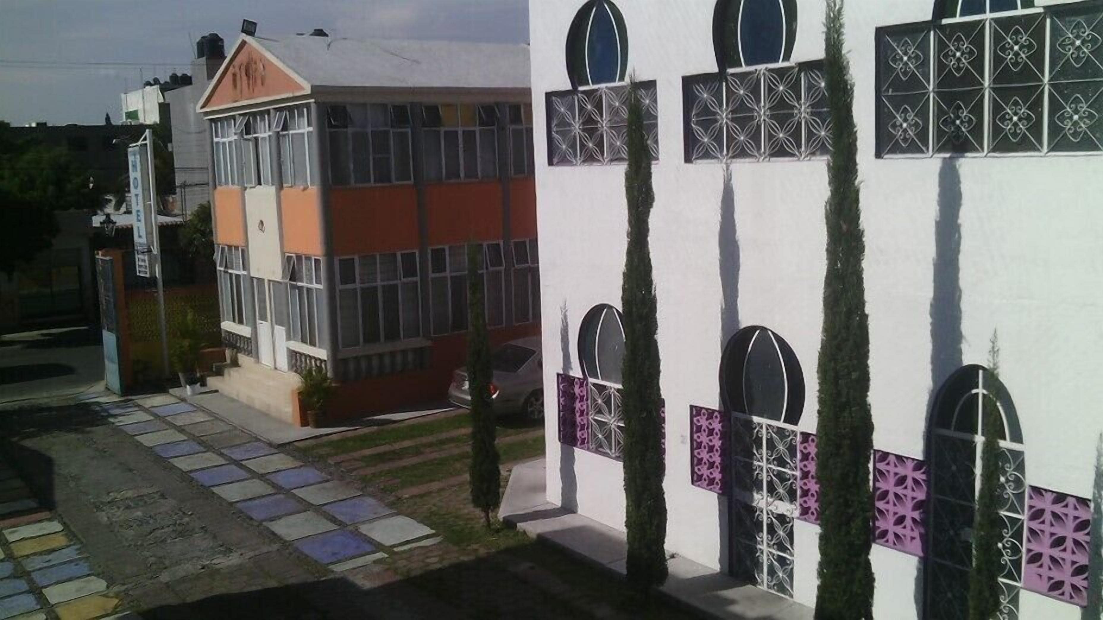 Een hotel met een modern ontwerp, met grote ramen en een opvallende oranje gevel.