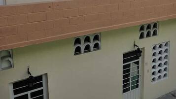 A two-story building with a flat roof, multiple windows, and a balcony.