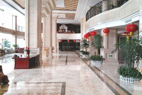 A spacious lobby with marble flooring, a reception desk, and red lanterns. - Gan Jiang Yuan International Hotel (Shicheng)