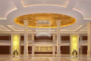 A spacious lobby with a central chandelier, multiple columns, and a reception desk. - Gan Jiang Yuan International Hotel (Shicheng)