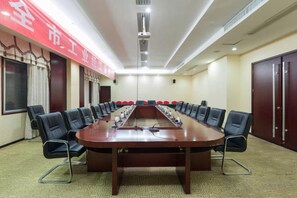 A conference room with a long table, chairs, and a red banner. - Gan Jiang Yuan International Hotel (Shicheng)