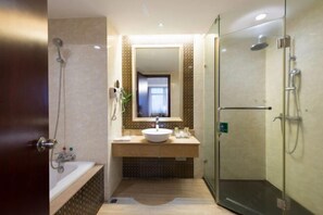 Un baño moderno con ducha de vidrio, bañera independiente y tocador con espejo.