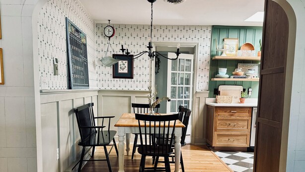 Une cuisine avec une table et des chaises en bois, un luminaire suspendu et une fenêtre donnant sur un beau paysage.
