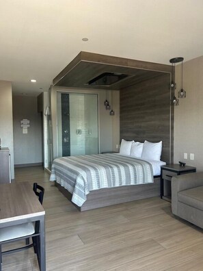A modern bedroom with a large bed, a desk, and a sofa. - Express Inn - Richey (Houston)