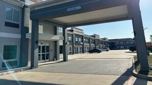 Entrada de un edificio moderno con un cartel que indica una altura libre de 4,5 metros.