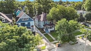 A residential area with multiple two-story houses, a well-maintained lawn, and a clear road.