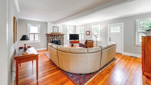 A spacious living room with a large L-shaped sectional sofa, a flat-screen TV, and a stone fireplace. - 2 Mi to Dtwn: 2-Acre Retreat w/ Large Yard! (Madison)