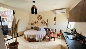 Un dormitorio moderno con cama, mesita de noche y un ventanal grande.