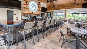 Ein Restaurant mit Außenbereich, Deckenventilatoren und einer Bar.