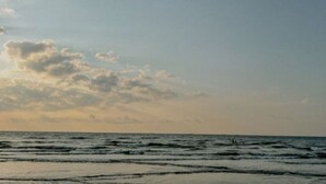 Una playa con olas y un cielo parcialmente nublado.