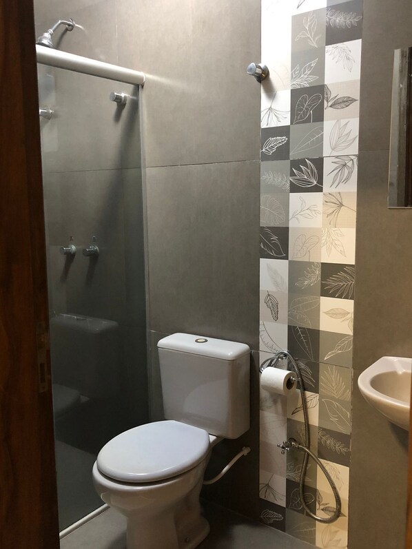 A bathroom with a toilet, a shower, and a sink. - Residence Hotel (Dourados)