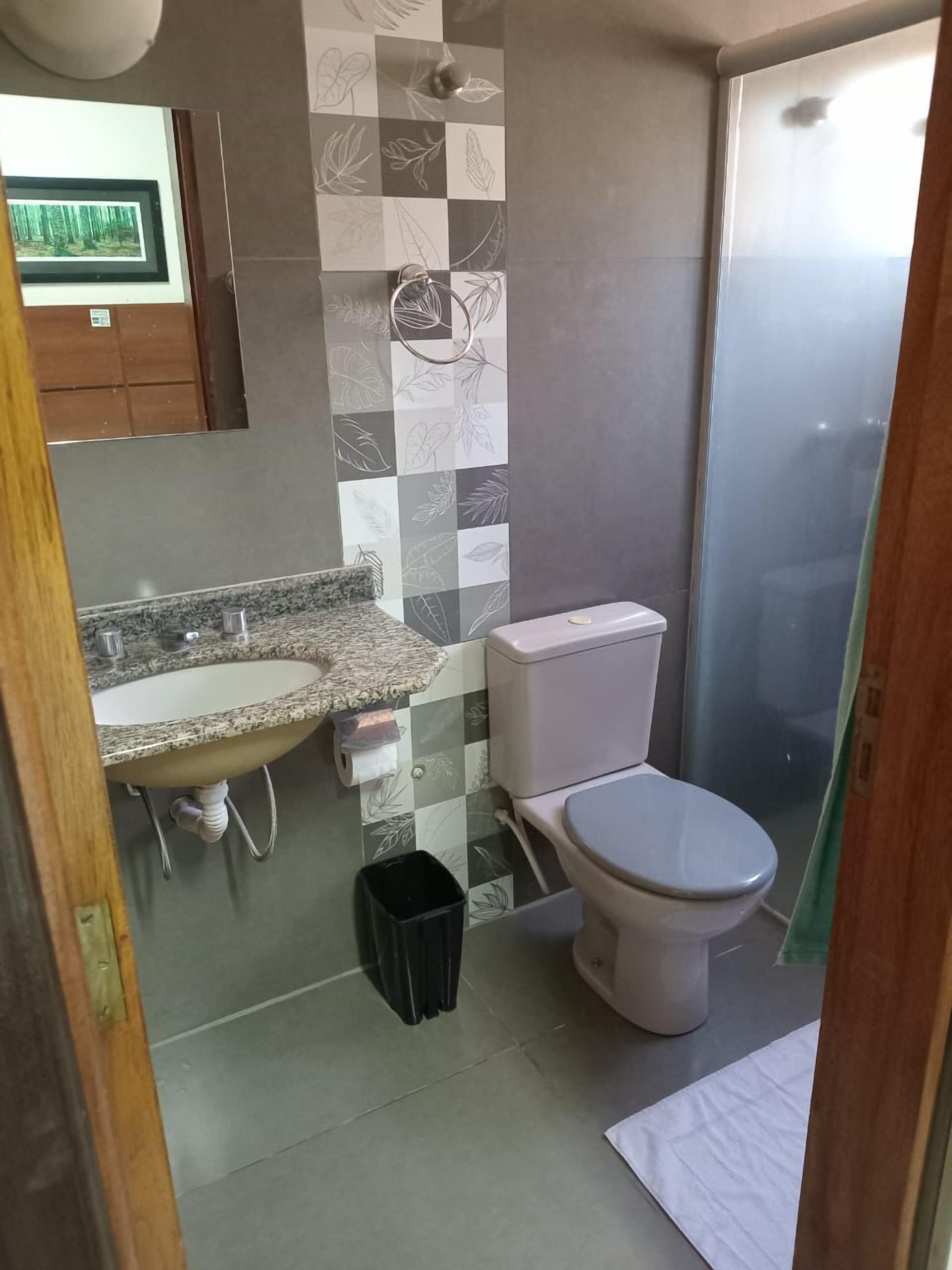 Un baño con lavamanos, inodoro y ducha.