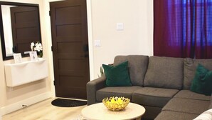 A modern living room with a grey sectional sofa, a round coffee table, and a patterned rug. - 2-bedroom vacation home just 13 minutes drive to Moda Center (Vancouver)