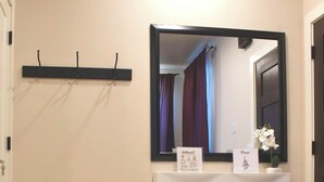 A room with a round table, a gold decorative bowl with lemons, a mirror, and a white cabinet with signs. - 2-bedroom vacation home just 13 minutes drive to Moda Center (Vancouver)