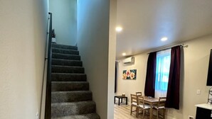 A staircase leading to a dining area with a table and chairs. - 2-bedroom vacation home just 13 minutes drive to Moda Center (Vancouver)