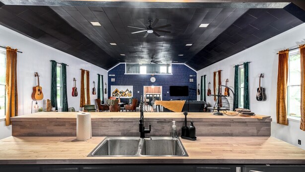 A kitchen with a central island, a sink, and a ceiling fan. - Cozy, sleeps 20 retreat in Auburn game area and large family entertaining (Auburn)