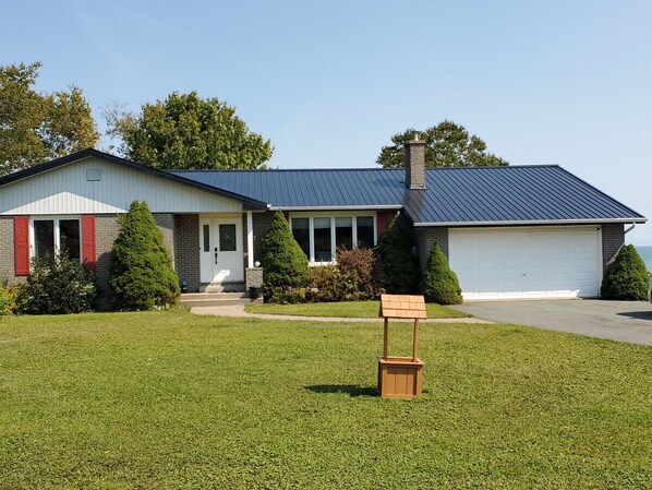 Einbungalow mit Garage, Veranda und gepflegtem Rasen.