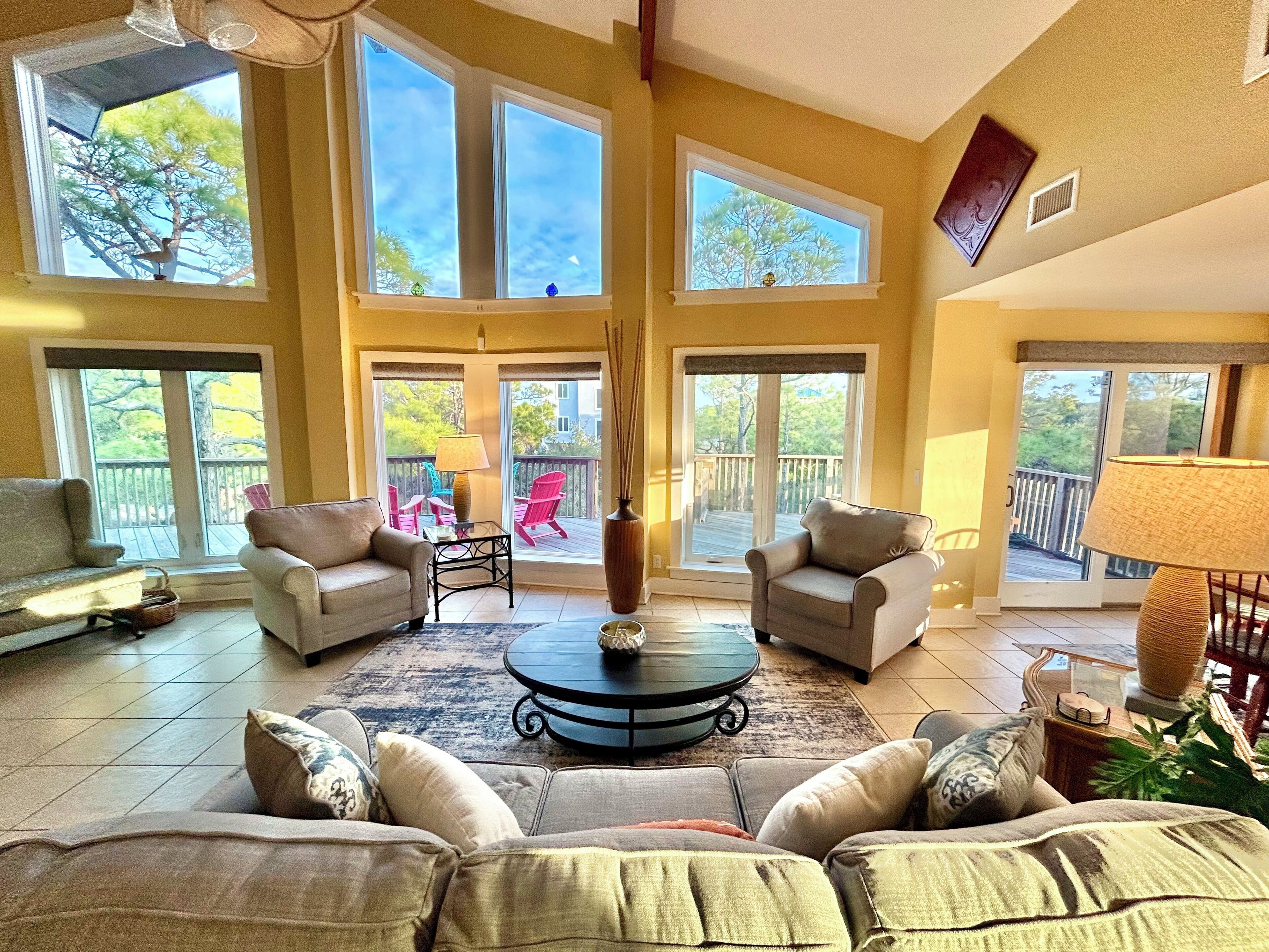 A spacious living room with large windows, a fireplace, and a balcony with outdoor furniture.
