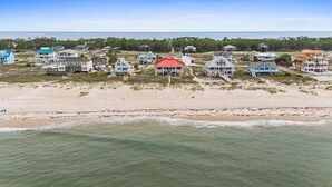 A coastal property with multiple beachfront houses, a pier, and a beach view. - See Escape-Beachfront, Pet Friendly, Hot Tub 4BR (St. George Island)