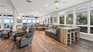 A spacious living area with a large sectional sofa, leather recliners, and a wooden coffee table.