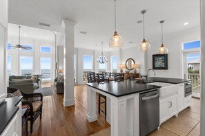 A spacious kitchen with a large island, white cabinetry, and a view of the ocean. - Southern Splendor, BF, Private Pool, 5BR (St. George Island)