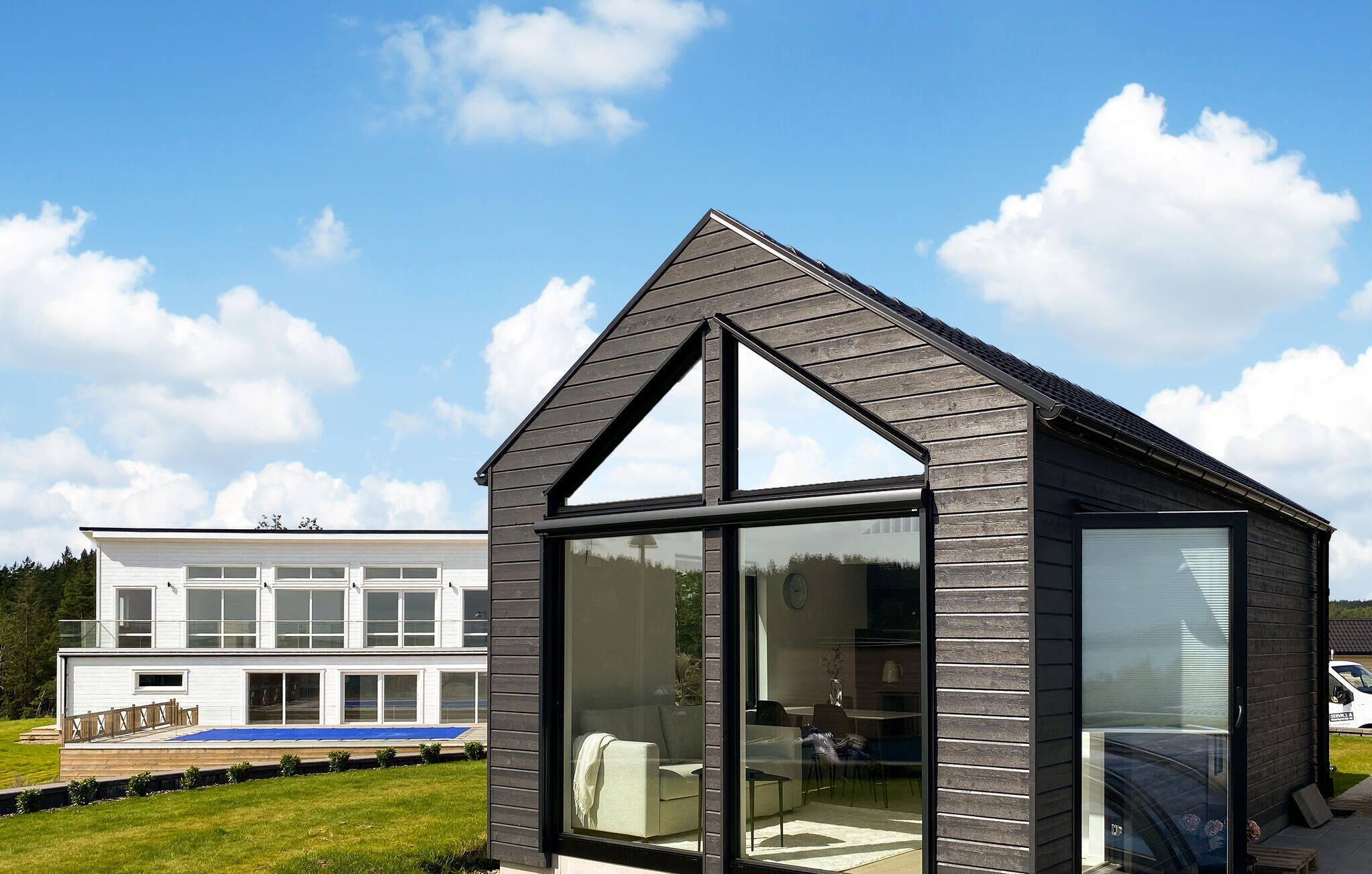 A modern house with a large glass front and a steeply pitched roof.