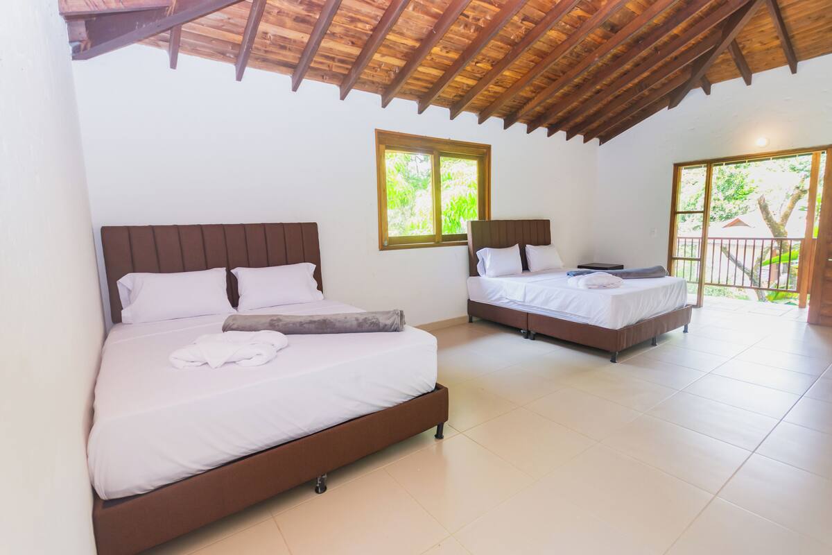 Two single beds with wooden headboards, white bedding, and a tiled floor.