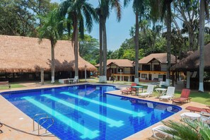 A swimming pool with lounge chairs and thatched-roof buildings. - La Selva Hotel San Jeronimo (San Jerónimo)